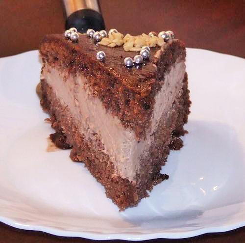 Felie de tort de ciocolata asezata pe o farfurie alba